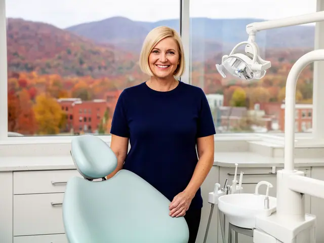 A dentist standing beside a dental chair.